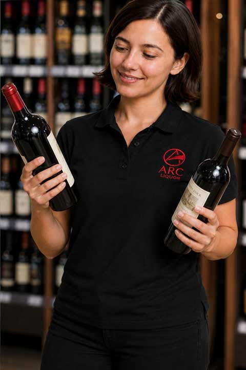 Emily holding a bottle of River Stone Merlot on an outdoor patio